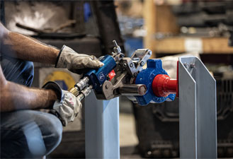A worker performs tool setup and operation of a TorqLite hydraulic wrench, essential for usage training.