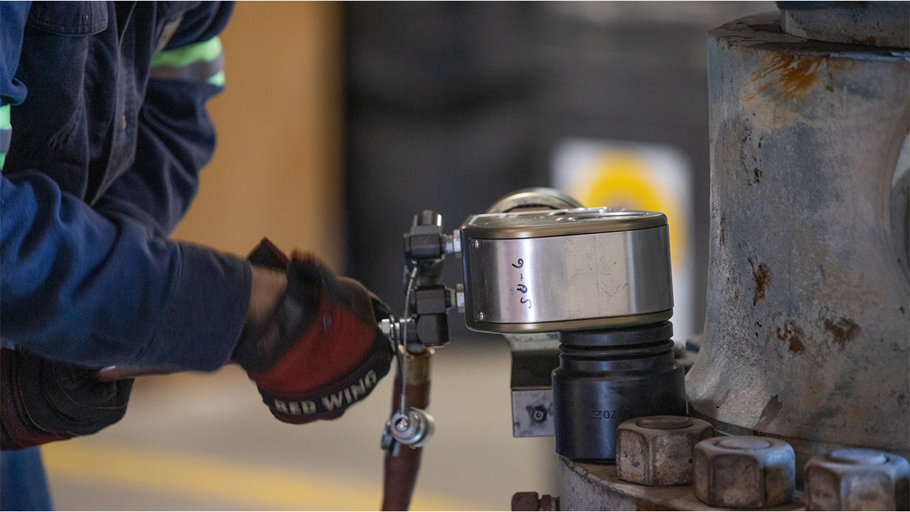 A worker using a TorqLite hydraulic torque wrench, from a leading hydraulic tools distributor.