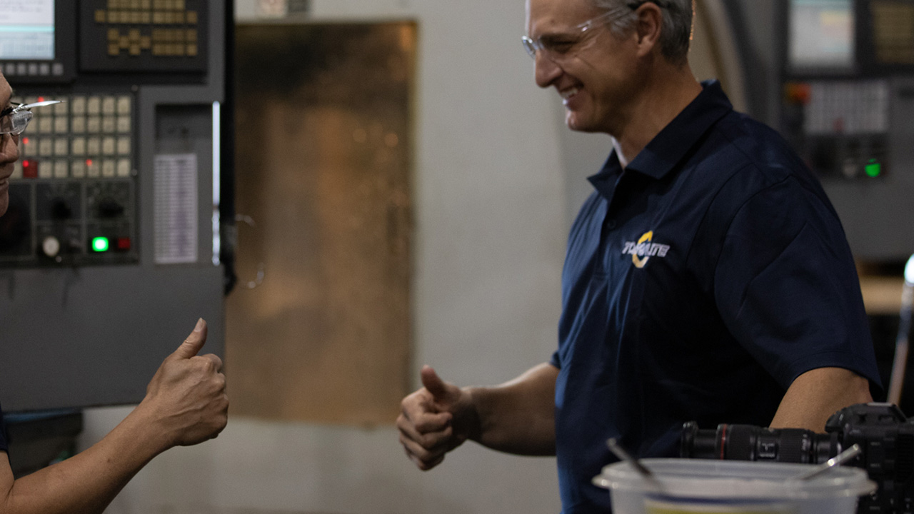 A TorqLite team member and a business partner giving a thumbs-up, representing a leading hydraulic tools distributor.